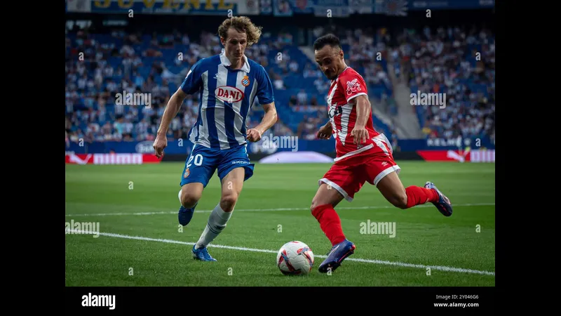 Cầu thủ Espanyol với bóng trước sự truy cản của cầu thủ Rayo Vallecano